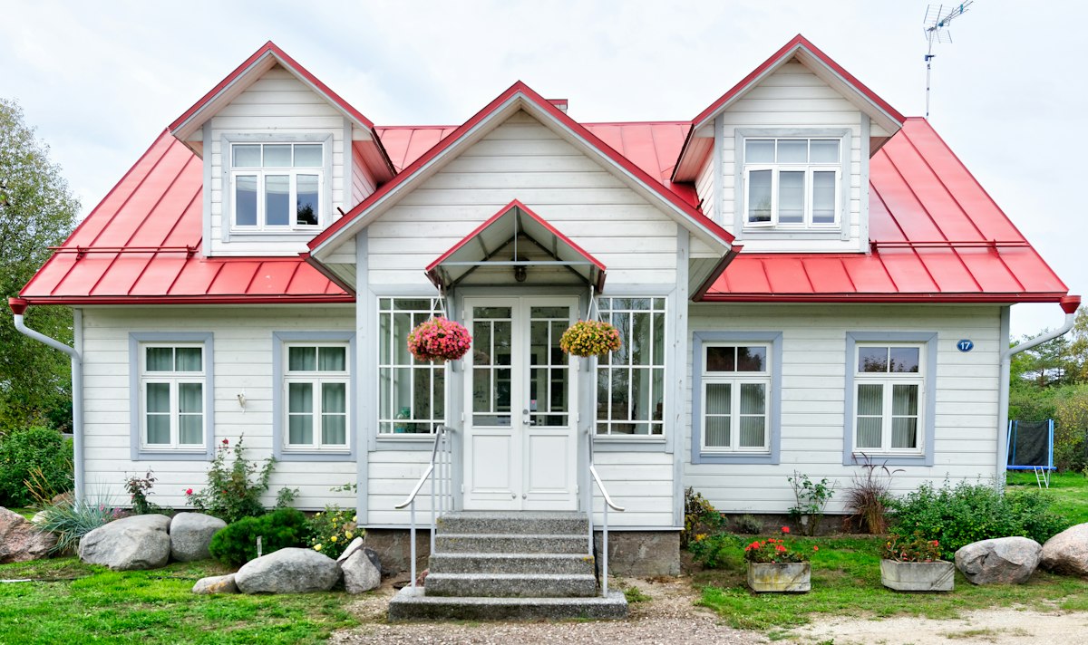White house with a red roof and flower boxes